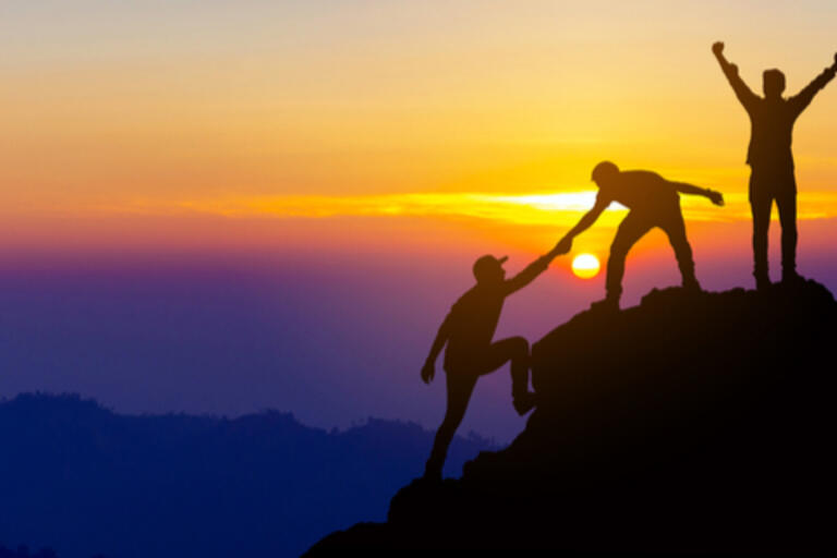 concept of people working together for success, climbing up mountain