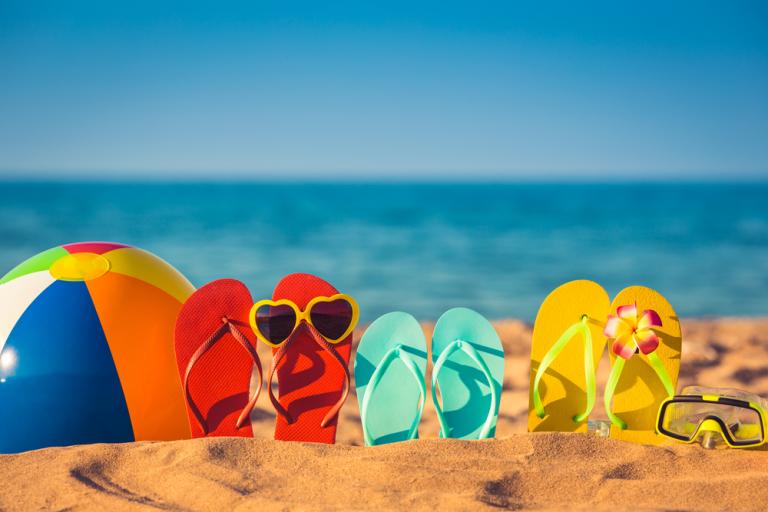 Beach ball and flip flops on a beach