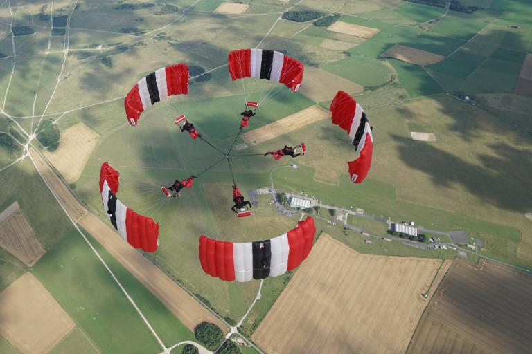 Five people in mid air having parachuted from an aeroplane