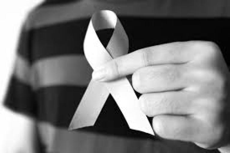 White Ribbon being held between two fingers, in black and white photo