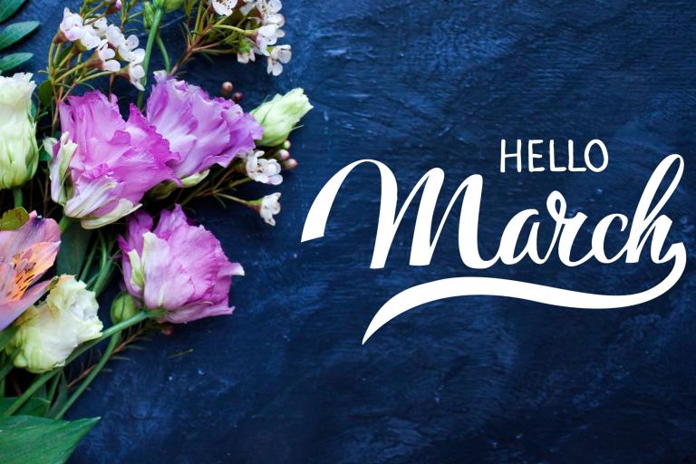 Words Hello March next to a bunch of spring flowers, set on a dark blue background