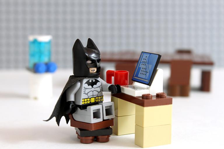 Lego batman sat at a lego laptop