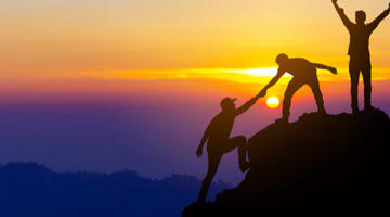 concept of people working together for success, climbing up mountain