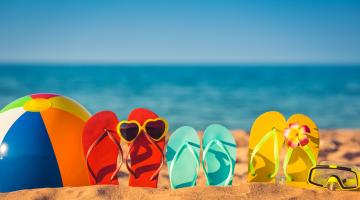 Beach ball and flip flops on a beach