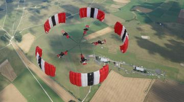 Five people in mid air having parachuted from an aeroplane