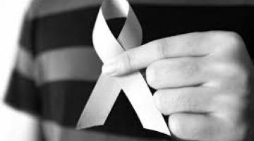 White Ribbon being held between two fingers, in black and white photo