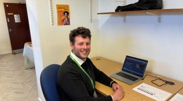 Man sitting at a desk and smiling