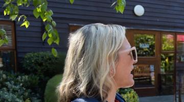 Informal photo of Nicole standing in the sun in conversation 