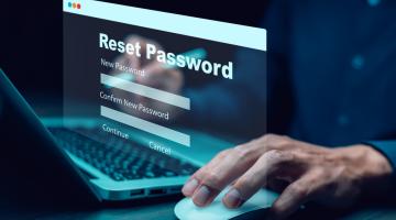 Fingertips at a keyboard with the words reset password floating above it