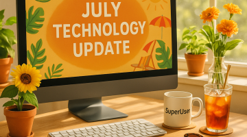 Laptop with July technology update on it, surrounded by sunflowers, a mug with 'superuser' on it and an iced tea
