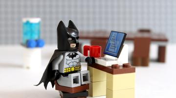 Lego batman sat at a lego laptop