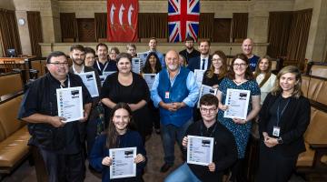 Photo of staff in the Council Chamber holding up their certificates