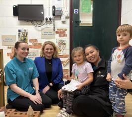 Photo of Cllr Louise McKinlay with two adults and two children, smiling and in a school setting