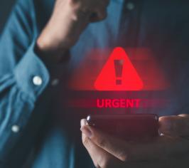 Man holding a phone with a hazard sign floating above it and the words urgent