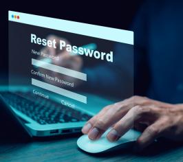 Fingertips at a keyboard with the words reset password floating above it