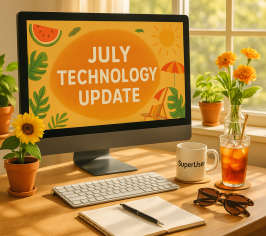 Laptop with July technology update on it, surrounded by sunflowers, a mug with 'superuser' on it and an iced tea