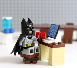 Lego batman sat at a lego laptop