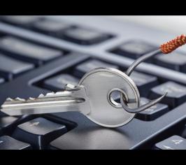 computer keyboard with silver fishing hook being dangled over it
